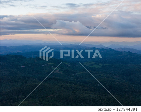 Mountainous landscape view under cloudy sky at dusk near rural area 127944891