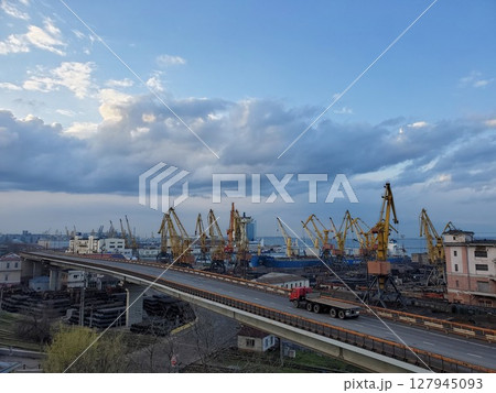 Industrial port landscape with red truck driving by overpass road 127945093