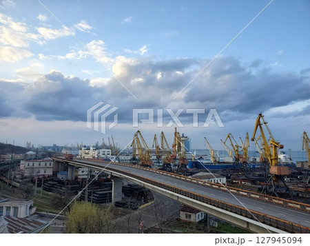 Industrial port landscape with cargo trucks driving by overpass 127945094