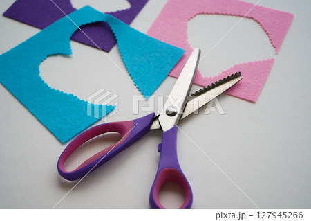 The scissors are lying on the pieces of felt. Needlework and sewing. 127945266