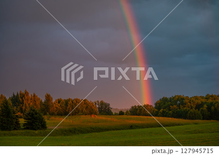 Colorful Rainbow Above Countryside at Golden Hour 127945715