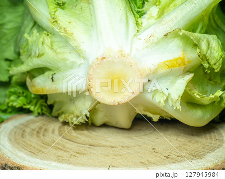 Bunch of lettuce on a wooden tray. Salad concept. Vitamin of natural origin. Leaves up close. Grass background for food. Useful ingredient. 127945984