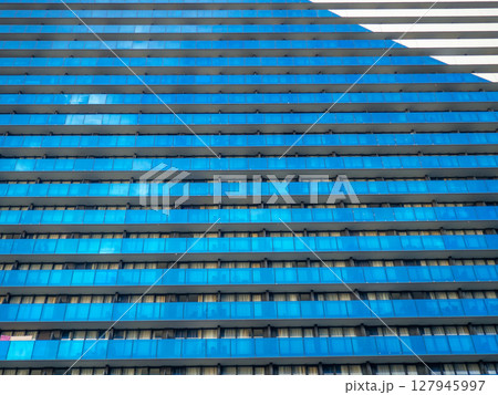 Background from the windows of a modern building. Tall building. Lots of windows. Skyscraper, floors. Human anthill. Modern hostel. Background from the windows of a modern building. Tall building. Lots of windows. Skyscraper, floors. Human anthill. Modern hostel. 127945997