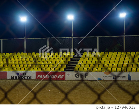 Beach soccer field through the fence mesh. Sand play concept. Competition sponsors. View of the viewer. Team Confrontation 127946015