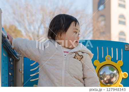 【相模原市立麻溝公園の子どもの広場の滑り台で遊ぶ1歳児】 127948343
