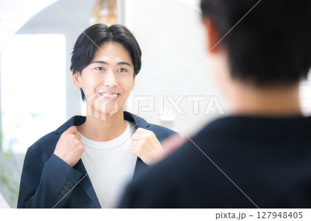 洗面台の鏡の前で朝の身だしなみをチェックする男性 洗面台の鏡の前で朝の身だしなみをチェックする男性 127948405