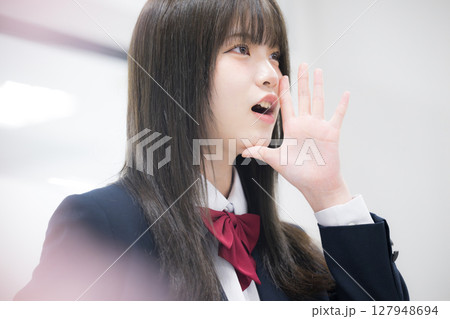 学校や塾で横顔笑顔の女子高生のクローズアップ 応援や声援で合格を目指す　桜の前ボケあり	 127948694