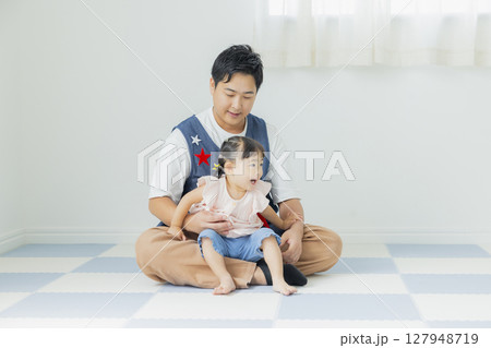 室内で遊ぶ子供と男性保育士 127948719
