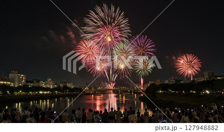 夏の夜空の花火大会と浴衣姿の観客 127948882