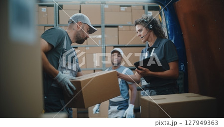 Multiethnic Workers Unloading Cardboard Boxes with E-Commerce Goods from Delivery Truck 127949363