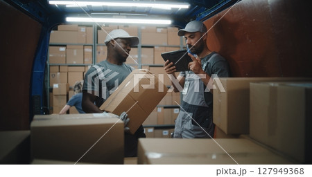 Employees Unloading Delivery Truck with Cardboard Boxes. Manager Scanning Parcels Using Digital Tablet Employees Unloading Delivery Truck with Cardboard Boxes. Manager Scanning Parcels Using Digital Tablet 127949368