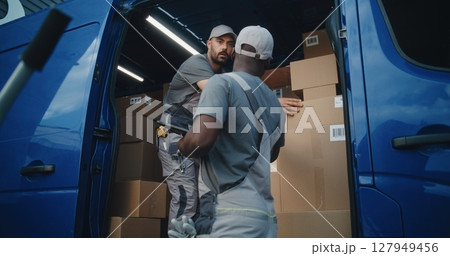 Male Employee Unloading Delivery Truck with Cardboard Boxes. Manager Using Digital Tablet 127949456