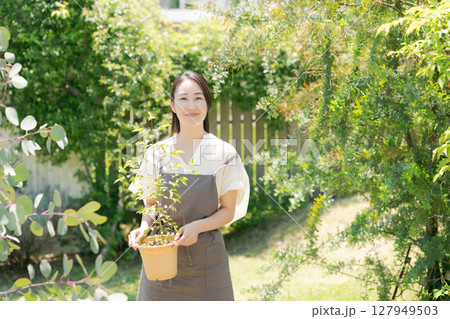 鉢植えを持つ女性 127949503