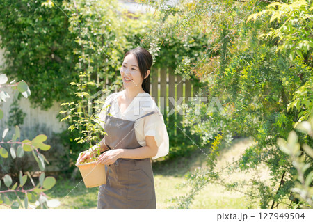 鉢植えを持つ女性 127949504