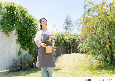 鉢植えを持つ女性 127950217