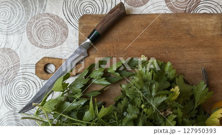 Chopped parsley on cutting board with knife 127950393