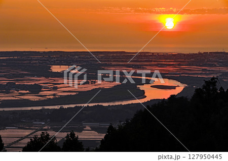 山形県眺海の森から広大な水田と最上川に映る夕日 127950445