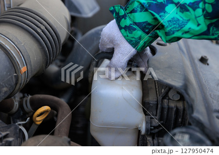 People going to refill the empty coolant tank of car People going to refill the empty coolant tank of car 127950474