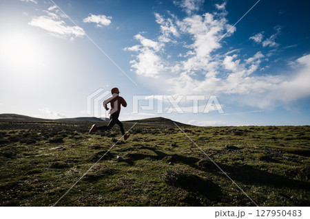 Woman trail runner cross country running to high altitude mountain peak Woman trail runner cross country running to high altitude mountain peak 127950483