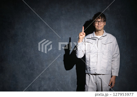 指差しする作業服の男性 127953977