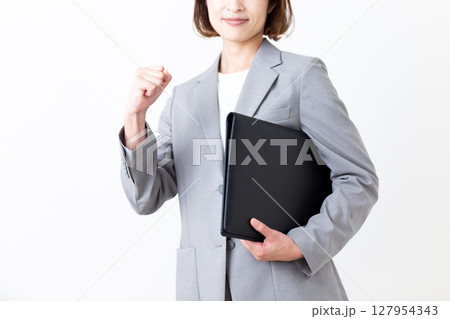 ファイルを持ってガッツポーズをするスーツ姿のミドル女性 127954343