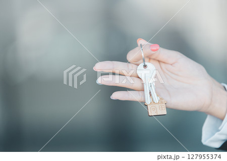 Woman hand hold key buy home model business concept involves sell financial management investment bank loan ownership income economy finance investments purchasing apartment blur background estate 127955374