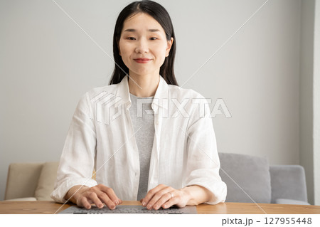 笑顔でパソコンを操作する女性 127955448