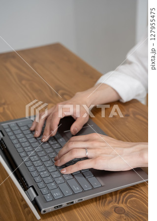 ノートパソコンで作業をする女性の手元 127955475