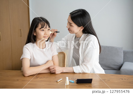 お母さんにメイクをしてもらう女の子 127955476