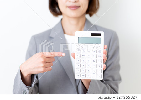 白い電卓を指差すスーツ姿のミドル女性 127955827