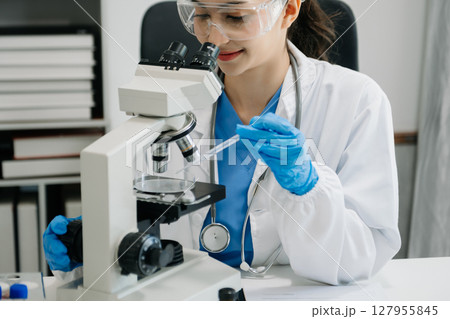 female scientist working with micro pipettes analyzing biochemical samples, advanced science chemical laboratory for medicine. female scientist working with micro pipettes analyzing biochemical samples, advanced science chemical laboratory for medicine. 127955845