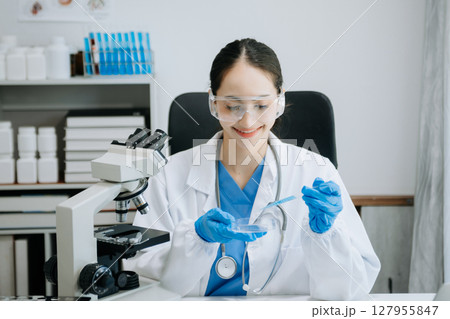 female scientist working with micro pipettes analyzing biochemical samples, advanced science chemical laboratory for medicine. female scientist working with micro pipettes analyzing biochemical samples, advanced science chemical laboratory for medicine. 127955847
