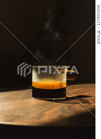 Espresso coffee in a glass cup on a dark background in vertical. Espresso coffee in a glass cup on a dark background in vertical. 127955856