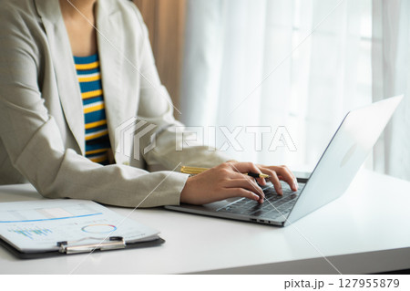 Young Woman Account Manager Working at Table with New Business Project. Typing keyboard,Using Contemporary Laptop. 127955879