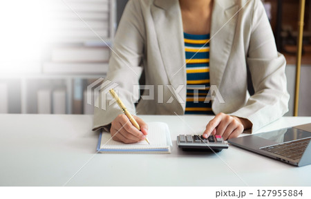 Businessman hands working with finances about cost and calculator and laptop with tablet, smartphone at office Businessman hands working with finances about cost and calculator and laptop with tablet, smartphone at office 127955884