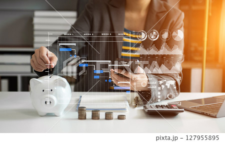 Business woman hand putting money coin into piggy bank with step of growing stack coins for saving money with virtual icon Business woman hand putting money coin into piggy bank with step of growing stack coins for saving money with virtual icon 127955895