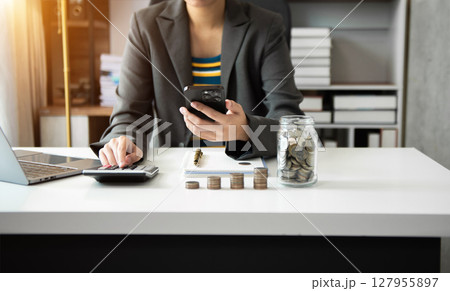 Hand putting mix coins and seed in clear bottle and business investment growth concept. at office 127955897