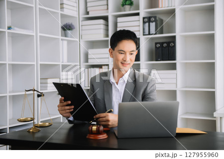 Attractive young lawyer in office Business man and lawyers discussing contract papers laptop and tablet with brass scale on desk in office. Attractive young lawyer in office Business man and lawyers discussing contract papers laptop and tablet with brass scale on desk in office. 127955960
