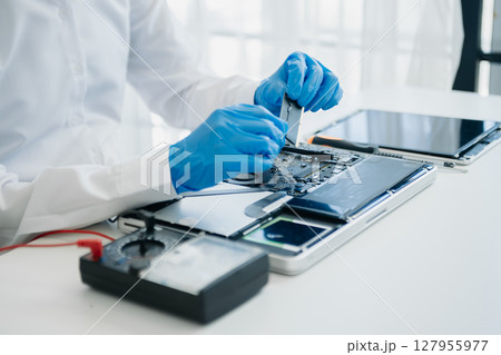 Electronics technician, electronic engineering electronic repair,electronics measuring and testing, repair and maintenance concepts.uses a voltage meter to check and upgrade in shop Electronics technician, electronic engineering electronic repair,electronics measuring and testing, repair and maintenance concepts.uses a voltage meter to check and upgrade in shop 127955977