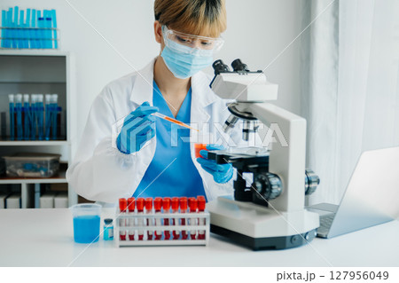 Modern medical research laboratory. female scientist working with micro pipettes analyzing biochemical samples, advanced science chemical laboratory Modern medical research laboratory. female scientist working with micro pipettes analyzing biochemical samples, advanced science chemical laboratory 127956049