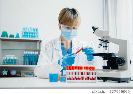 Modern medical research laboratory. female scientist working with micro pipettes analyzing biochemical samples, advanced science chemical laboratory Modern medical research laboratory. female scientist working with micro pipettes analyzing biochemical samples, advanced science chemical laboratory 127956069