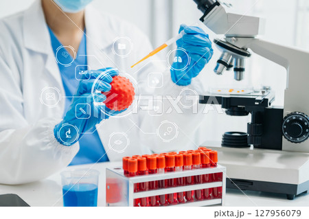 DNA molecule testing concepts. The doctor in a mask examines DNA molecules on the chemical laboratory with virtual icon DNA molecule testing concepts. The doctor in a mask examines DNA molecules on the chemical laboratory with virtual icon 127956079