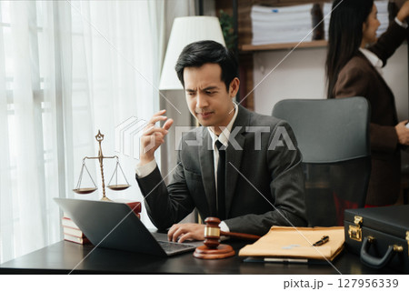 Business Asian people and lawyers discussing contract papers sitting at the table. Concepts of law, advice, legal services. 127956339