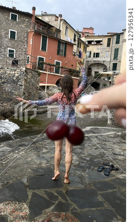 Playful Pose with Cherry Trick in Quaint Village Playful Pose with Cherry Trick in Quaint Village 127956341