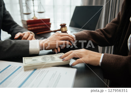 Judge gavel with scales of justice, Business and lawyer or counselor consulting and discussing contract papers with laptop and tablet at law firm Judge gavel with scales of justice, Business and lawyer or counselor consulting and discussing contract papers with laptop and tablet at law firm 127956351