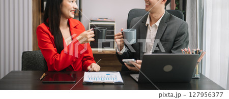 Asian business colleague business presents and explains and using laptop and tablet. Teamwork, financial marketing team, while sitting in modern office Asian business colleague business presents and explains and using laptop and tablet. Teamwork, financial marketing team, while sitting in modern office 127956377