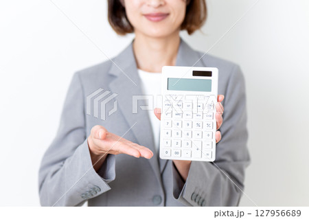 白い電卓を持つスーツ姿のミドル女性 127956689