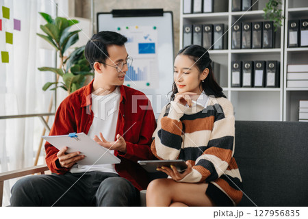 Portrait of success business people working together in home office. Couple teamwork startup concept Portrait of success business people working together in home office. Couple teamwork startup concept 127956835