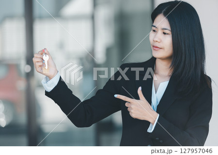 Woman hand hold key buy home model business concept involves sell financial management investment bank loan ownership income economy finance investments purchasing apartment blur background estate 127957046