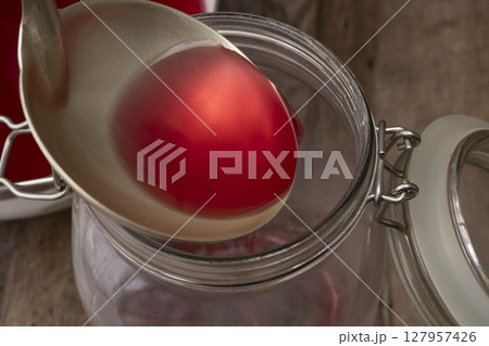 砂糖を使わない煮出した赤紫蘇のジュースを保存瓶に入れる 砂糖を使わない煮出した赤紫蘇のジュースを保存瓶に入れる 127957426